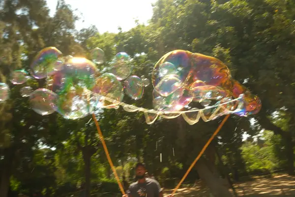 逆光下一串巨大的彩色泡泡，画面整体失焦